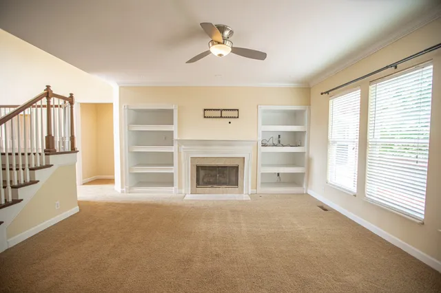 a view of an empty room with a fireplace and a window