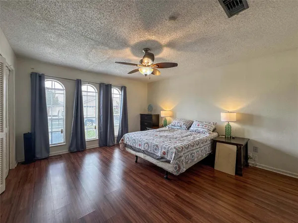 a bedroom with a large bed and a chandelier