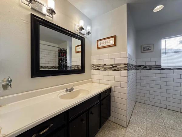 a bathroom with a sink vanity and mirror