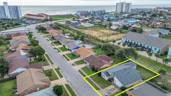 an aerial view of residential houses with outdoor space and parking