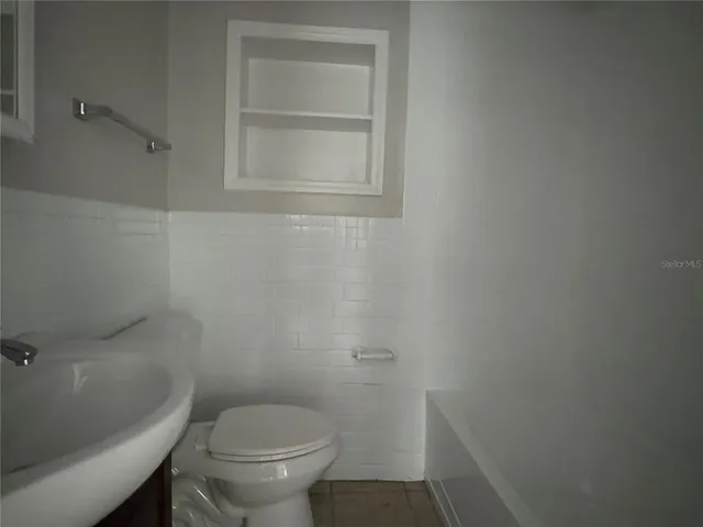 a white toilet sitting next to a shower
