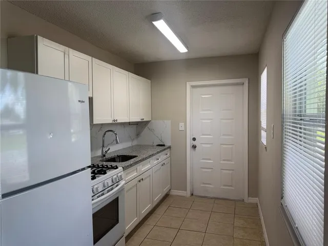 a kitchen with white cabinets and white appliances
