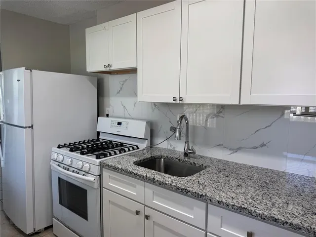 a kitchen with appliances a sink and cabinets