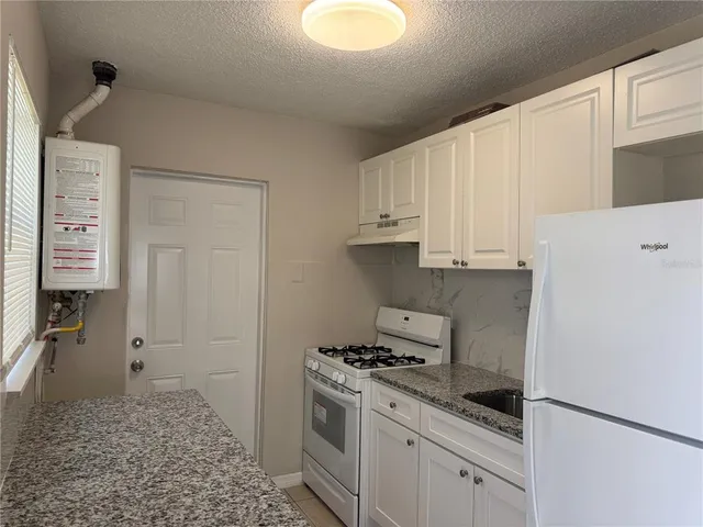 a kitchen with a stove a refrigerator and cabinets