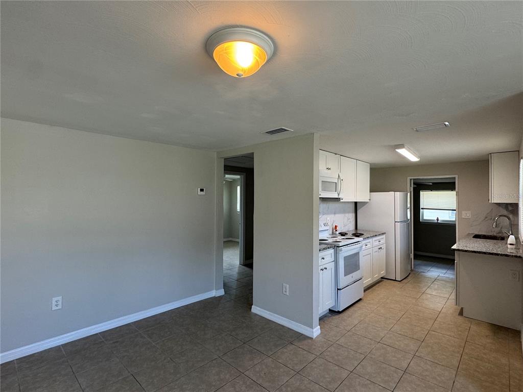809 West Warren Street Plant City, FL 33563 - Photo 6 of 28 a kitchen with stainless steel appliances granite countertop a stove a sink and a refrigerator