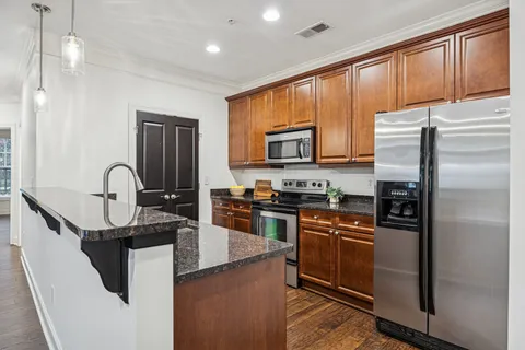 a kitchen with stainless steel appliances granite countertop a sink stove and refrigerator