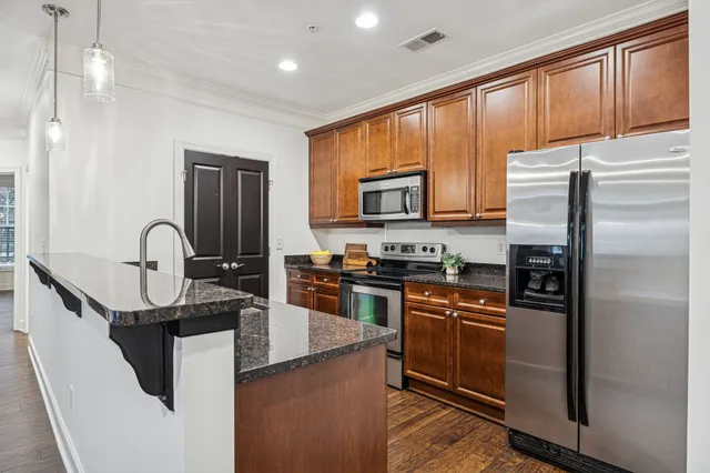 a kitchen with stainless steel appliances granite countertop a sink stove and refrigerator
