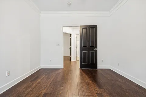 a bedroom with a bed lamps and wooden floor