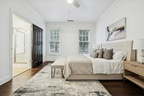 an empty room with wooden floor cabinet and windows