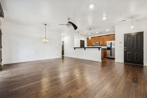 a view of a kitchen with a wooden floor and a ceiling fan