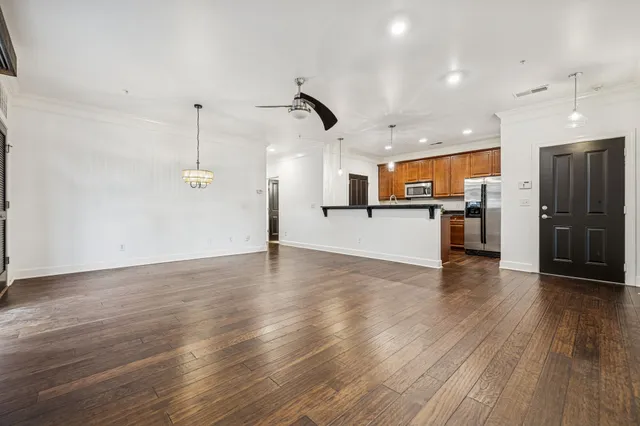 a view of a kitchen with a wooden floor and a ceiling fan