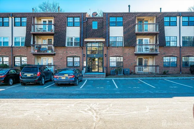 a view of a brick house with a yard next to a road