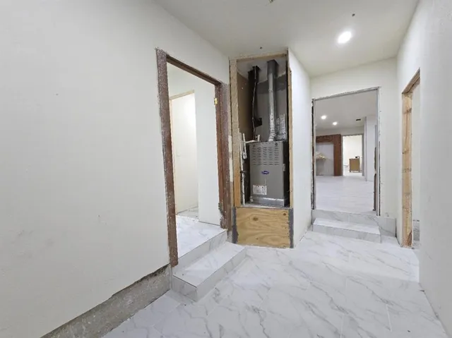 an empty room with mirror and a bathroom