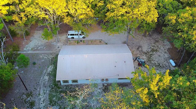 an aerial view of a house with pool and garden