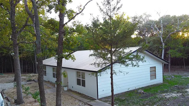 a view of a house with backyard and trees