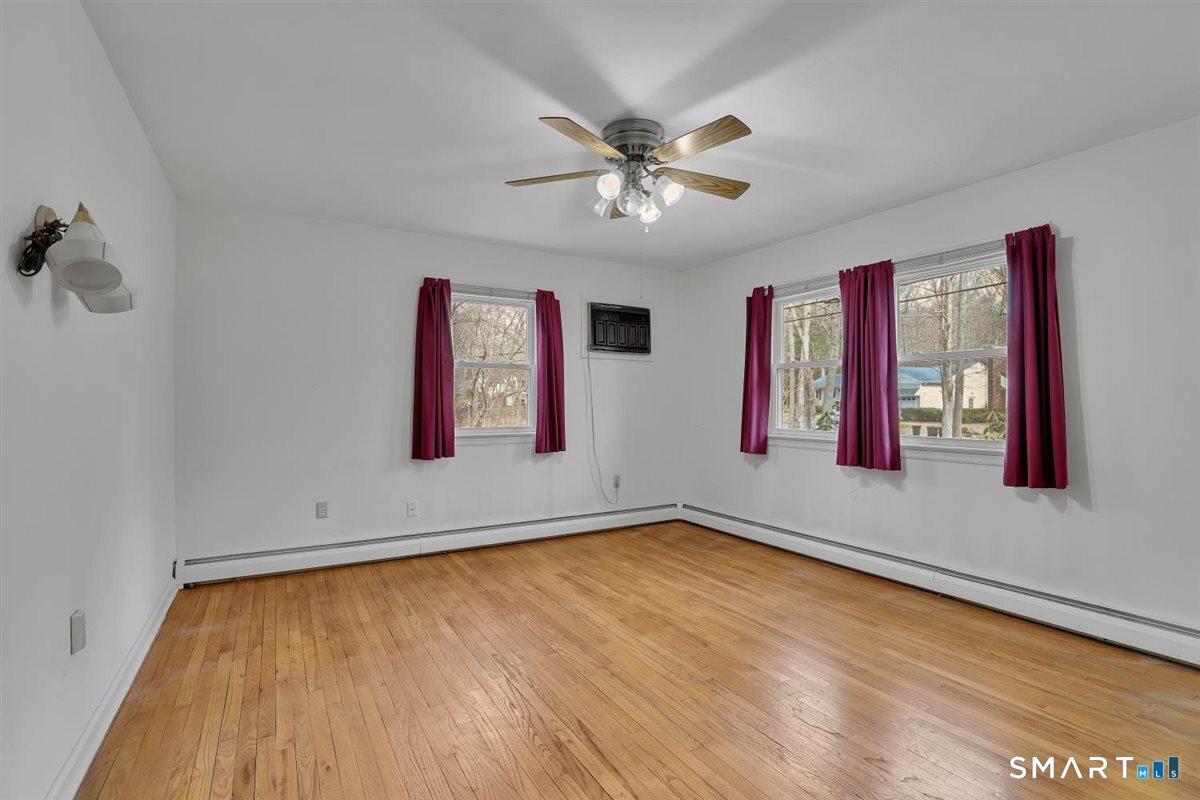 47 Park Road Colchester, CT 06415 - Photo 12 of 31 Main floor bright bedroom featuring hardwood floors, wall AC and ceiling fan to keep you comfortable.