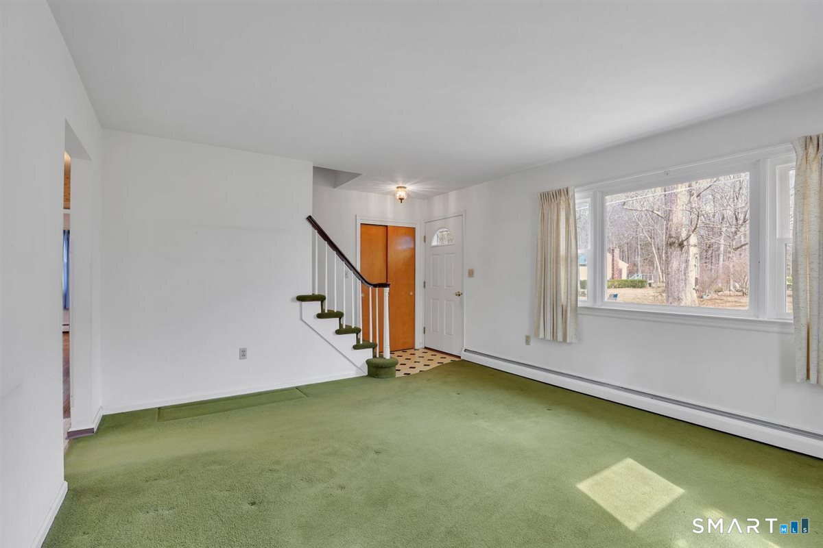 47 Park Road Colchester, CT 06415 - Photo 5 of 31 Bright and inviting living space features a large picture window and Harvey replacement side windows. Main entry offers a storage closet and a space for coats and shoes.