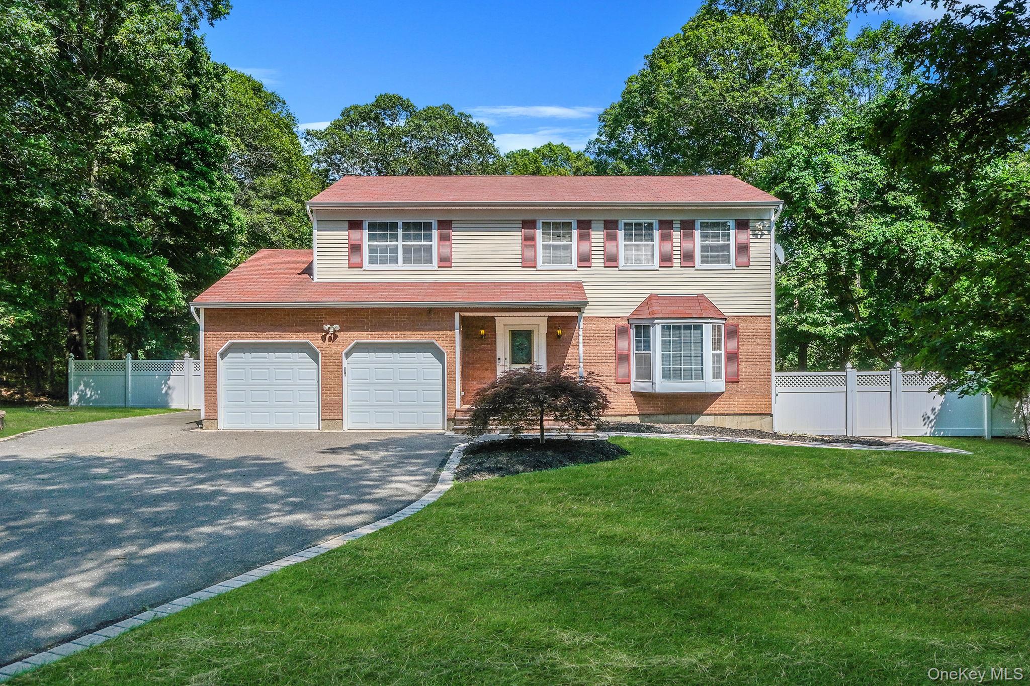 125 West Bartlett Road Middle Island, NY 11953 - Photo 1 of 1 View of front facade with asphalt driveway, brick siding, and a garage