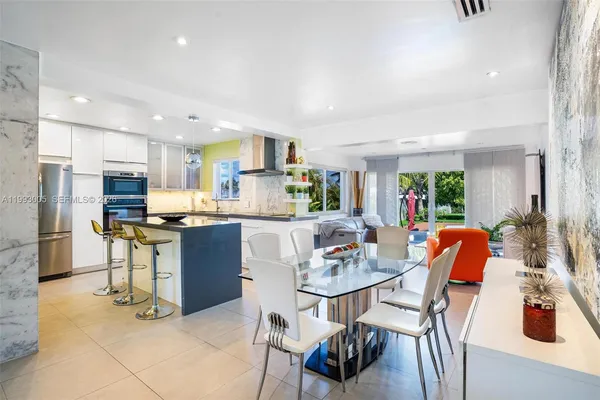 a kitchen with stainless steel appliances kitchen island granite countertop a table and chairs in it