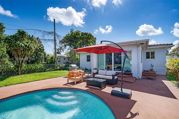 a backyard of a house with table and chairs