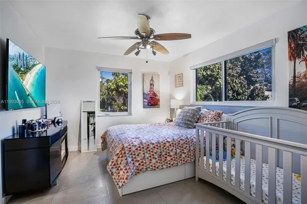 a bedroom with a bed dresser and a flat screen tv