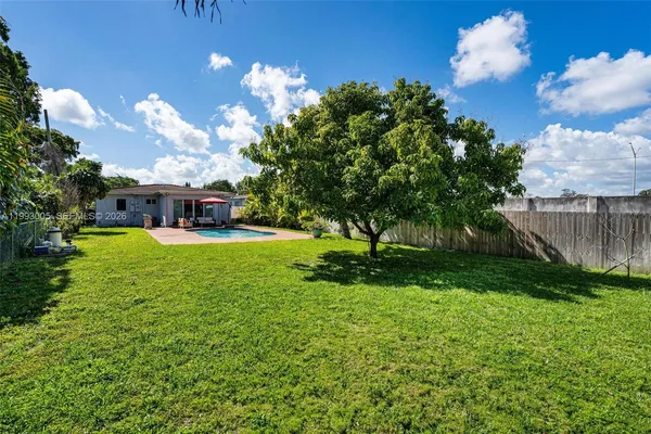 a view of a house with swimming pool and a yard