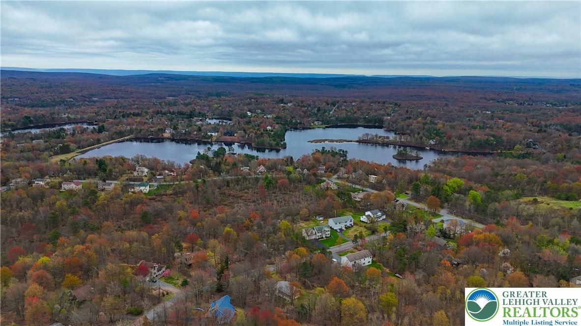 2742 Long Pond Road Long Pond, PA 18334 - Photo 5 of 57 Lakeside living offers a serene retreat amidst an autumnal forest canopy.