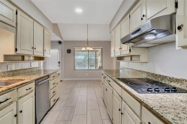 a kitchen with stainless steel appliances granite countertop a sink stove and cabinets