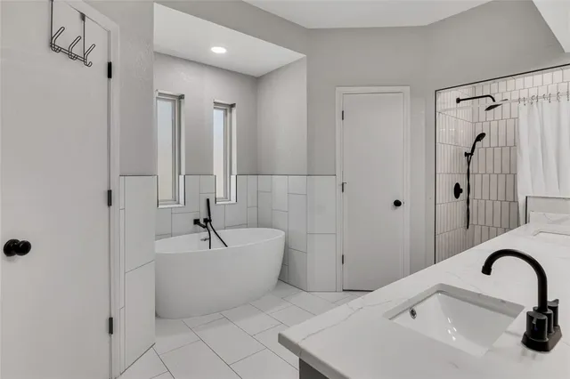 a bathroom with a sink a mirror a bathtub and shower