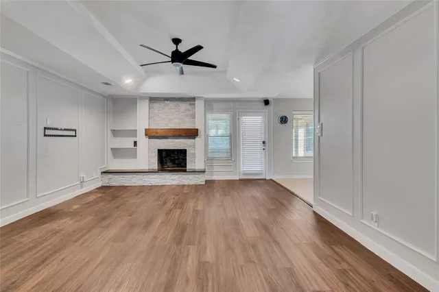 a view of empty room with wooden floor fireplace and windows