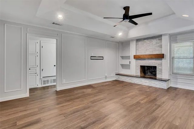 a view of empty room with wooden floor and fireplace