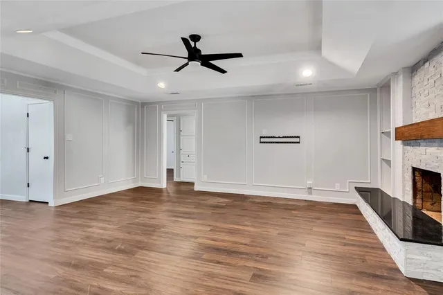 a view of empty room with wooden floor and ceiling fan
