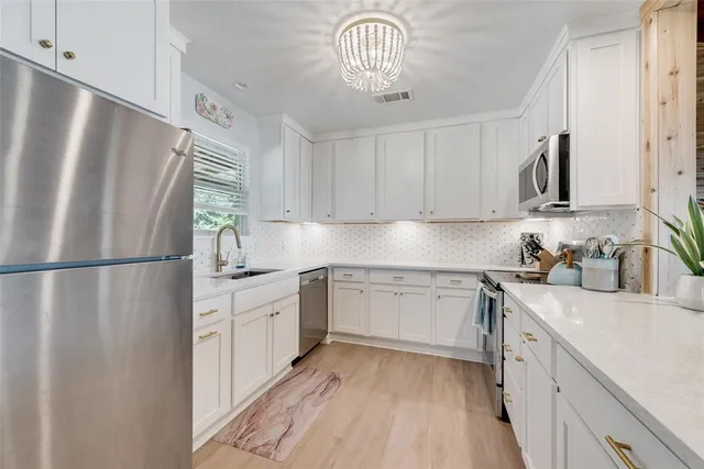 a kitchen with stainless steel appliances a refrigerator sink and cabinets