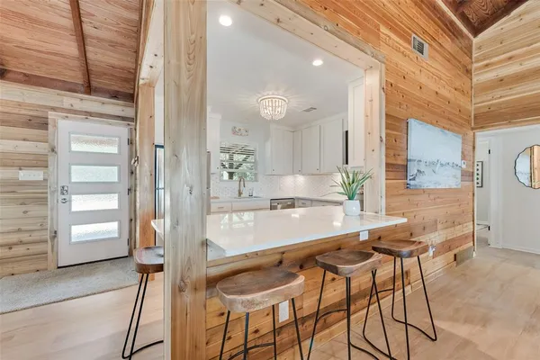 a dining hall with stainless steel appliances kitchen island granite countertop a table and chairs