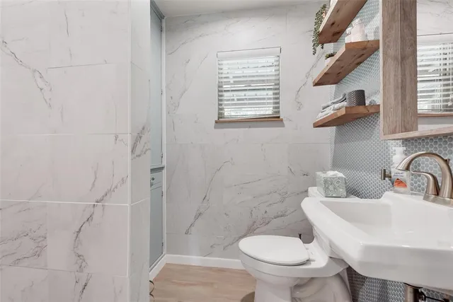 a bathroom with a toilet sink and mirror