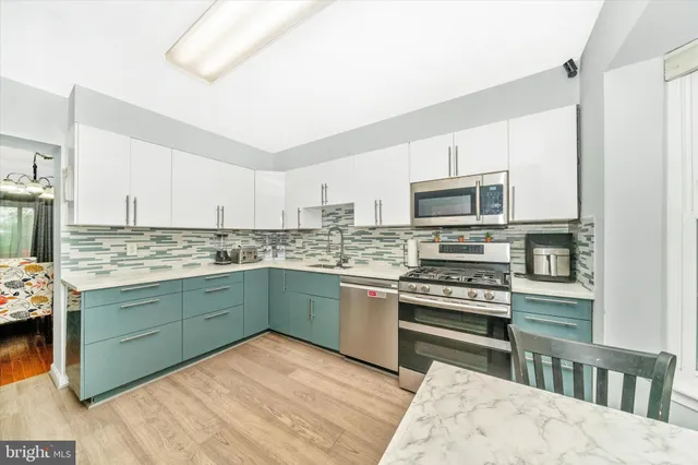 a kitchen with stainless steel appliances granite countertop a stove top oven a sink dishwasher and white cabinets