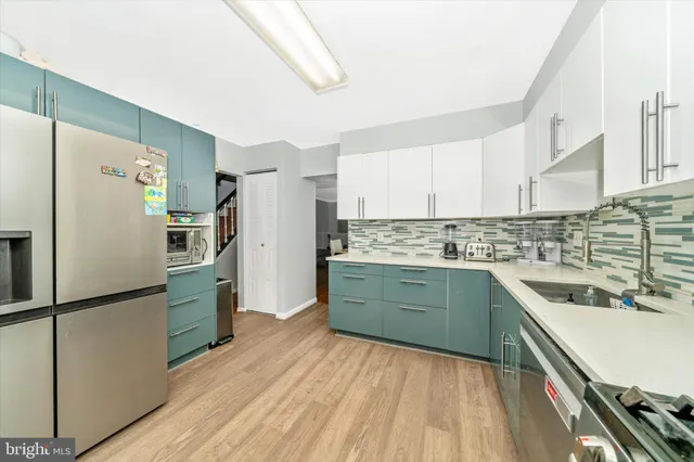a kitchen with a refrigerator a sink and cabinets