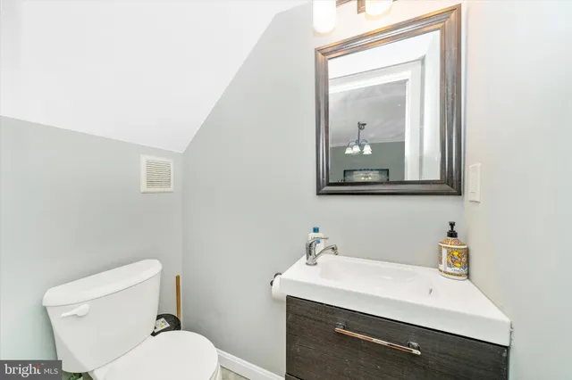 a bathroom with a toilet a sink and mirror