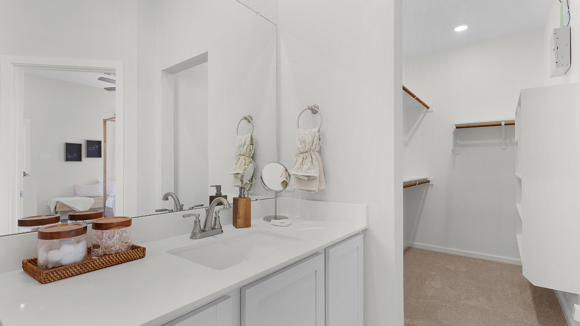 25812 Jasmine Sprig Lane Elgin, TX 78621 - Photo 14 of 33 A well-lit primary bathroom vanity with direct access to a spacious walk-in closet.