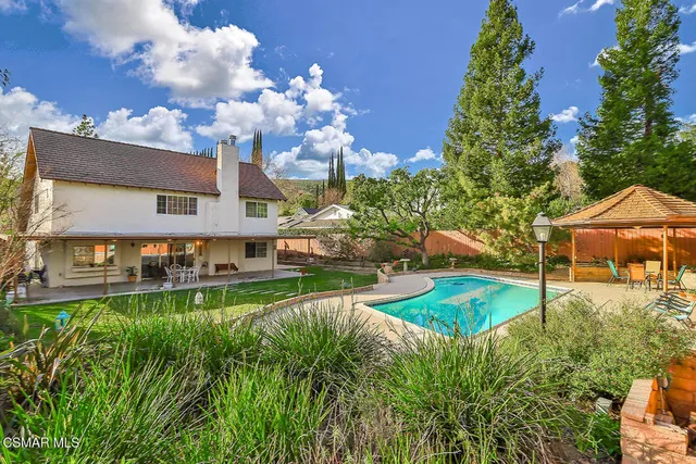 a view of a house with a big yard and potted plants
