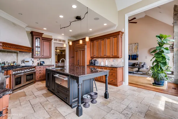 a kitchen with stainless steel appliances granite countertop a stove top oven a sink dishwasher a dining table and chairs with wooden floor