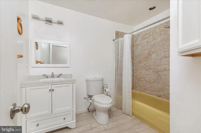 a bathroom with a granite countertop sink a toilet and shower