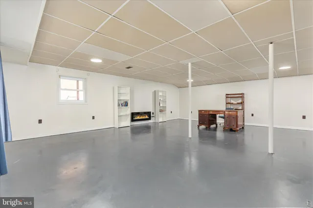 a view of a water heater room with wooden floor and lounge chairs
