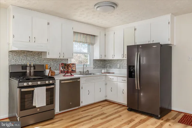 a kitchen with stainless steel appliances granite countertop a stove a refrigerator and a cabinets