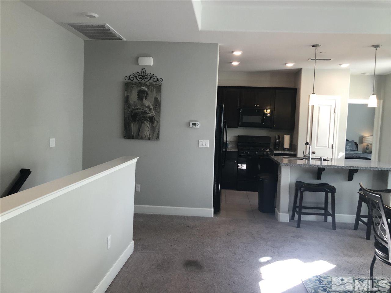 2017 Wind Ranch Road, Unit A Reno, NV 89521 - Photo 8 of 13 a living room with furniture and a chandelier