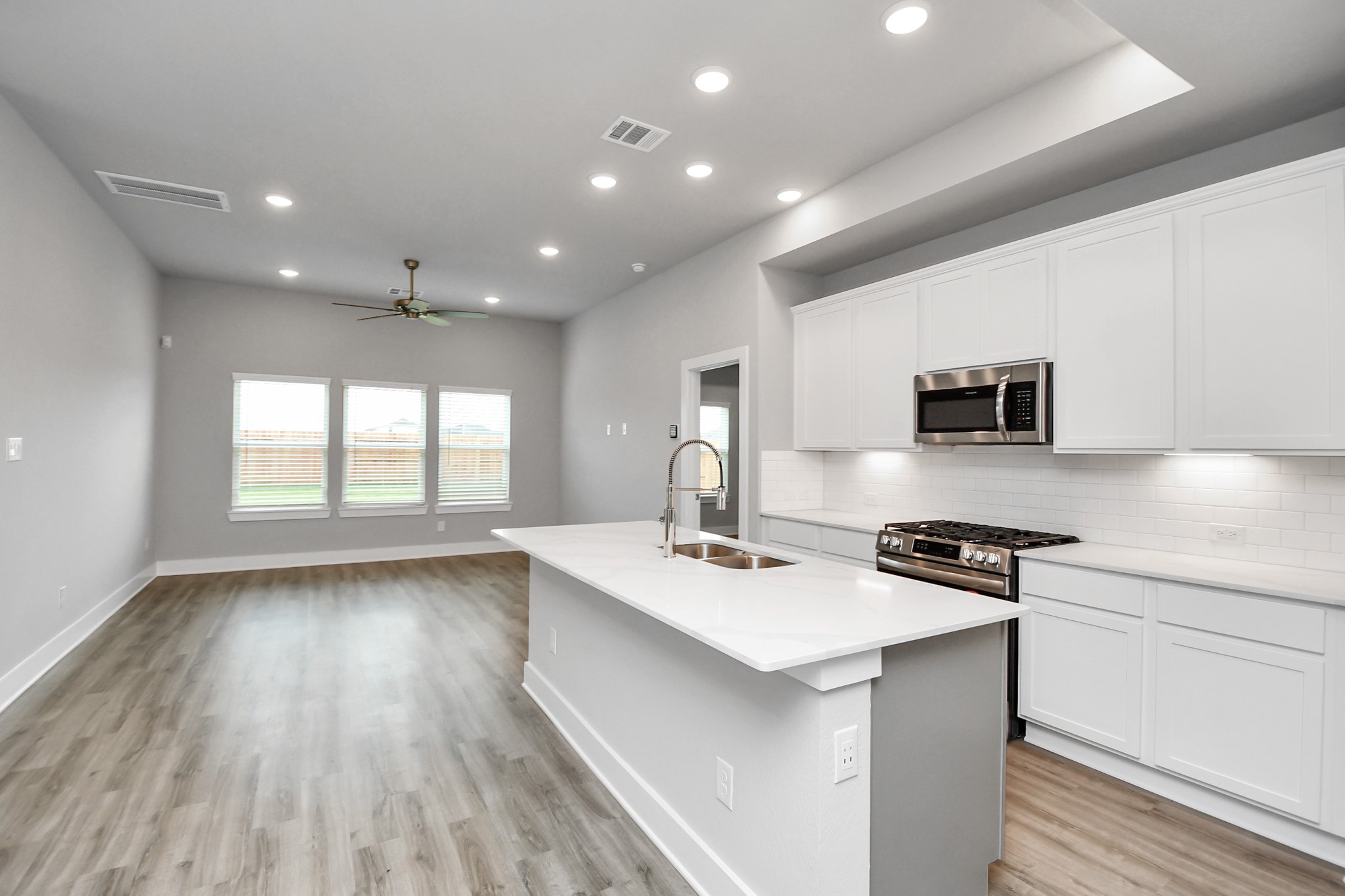7514 Terramar Bay Lane Cypress, TX 77433 - Photo 3 of 23 a kitchen with stainless steel appliances a stove top oven a sink dishwasher and a refrigerator with wooden floor