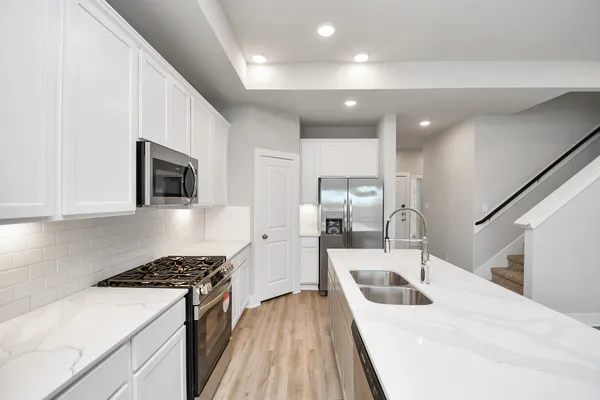 a kitchen with stainless steel appliances kitchen island a stove a sink and a refrigerator
