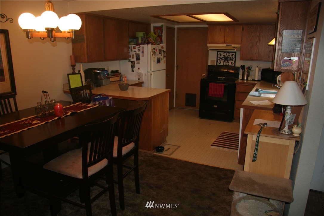 17 Madison Street Everett, WA 98203 - Photo 4 of 8 a kitchen with a table chairs and refrigerator