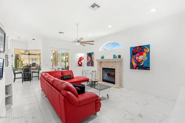 a living room with furniture a fireplace and a chandelier