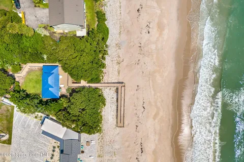 a view of a patio with a table and chairs under an umbrella with potted plants